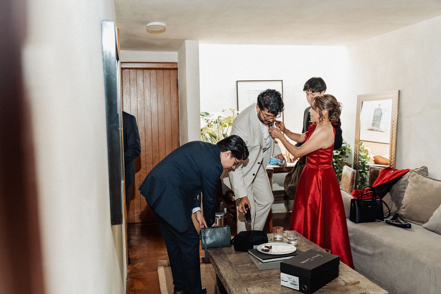 A couple in dark attire and a red dress dance intimately in different candid moments throughout an interior space.