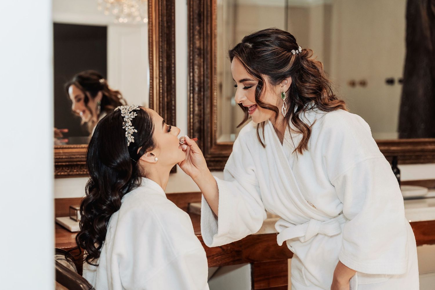 Wedding preparation moment with makeup application in front of vanity mirror.