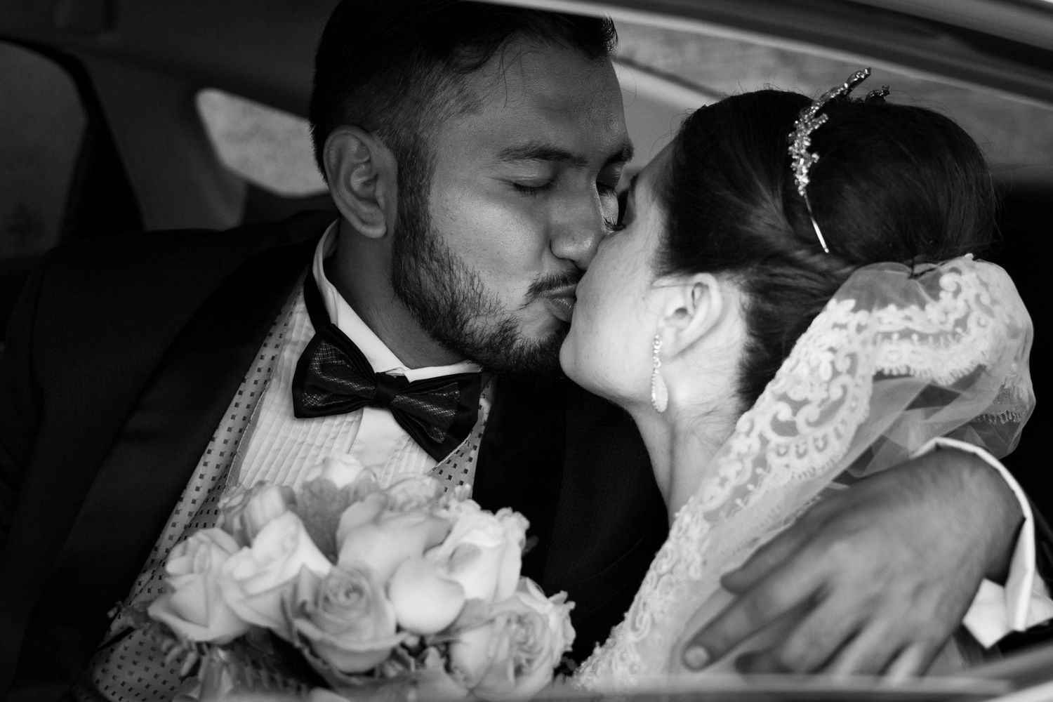 A romantic black and white portrait of newlyweds sharing an intimate moment.