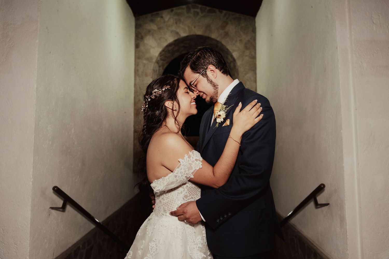 A romantic wedding couple shares intimate kisses in a series of black and white photos along a hallway.