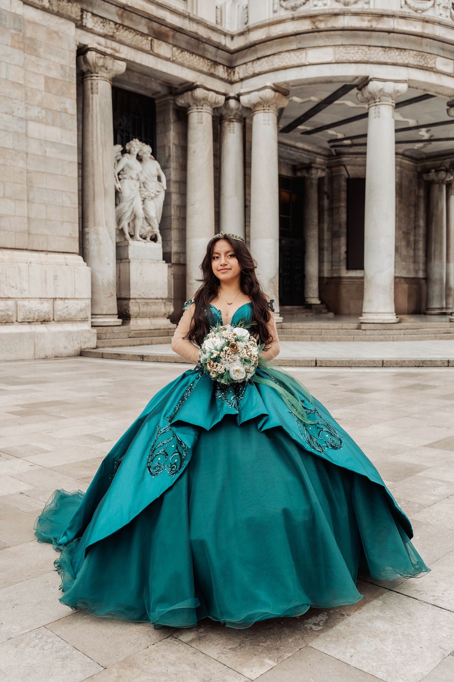 A stunning turquoise quinceañera ball gown displayed in various poses against a classical stone colonnade backdrop.
