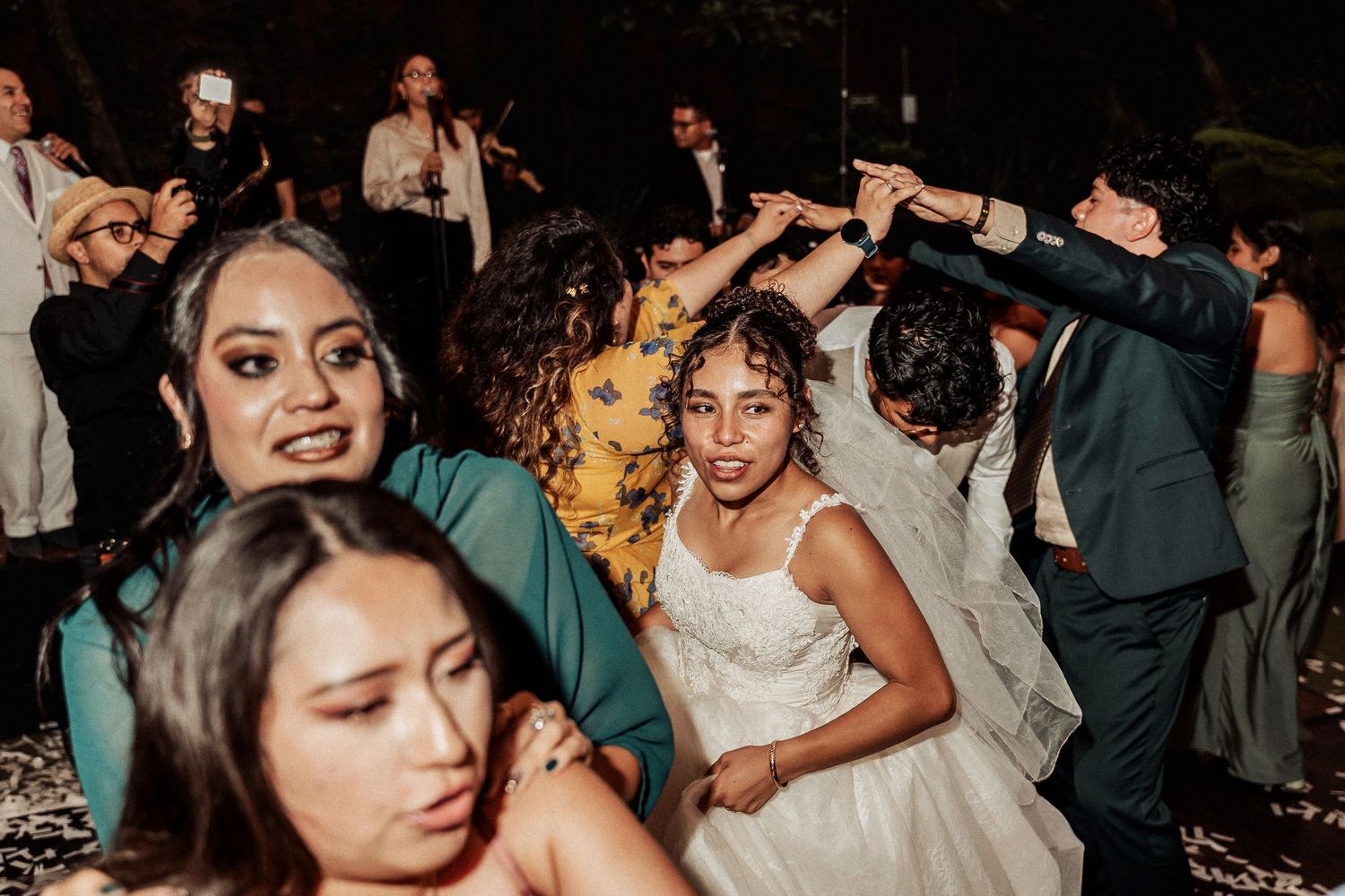 Lively wedding reception dance floor with guests enjoying the celebration under ambient lighting.
