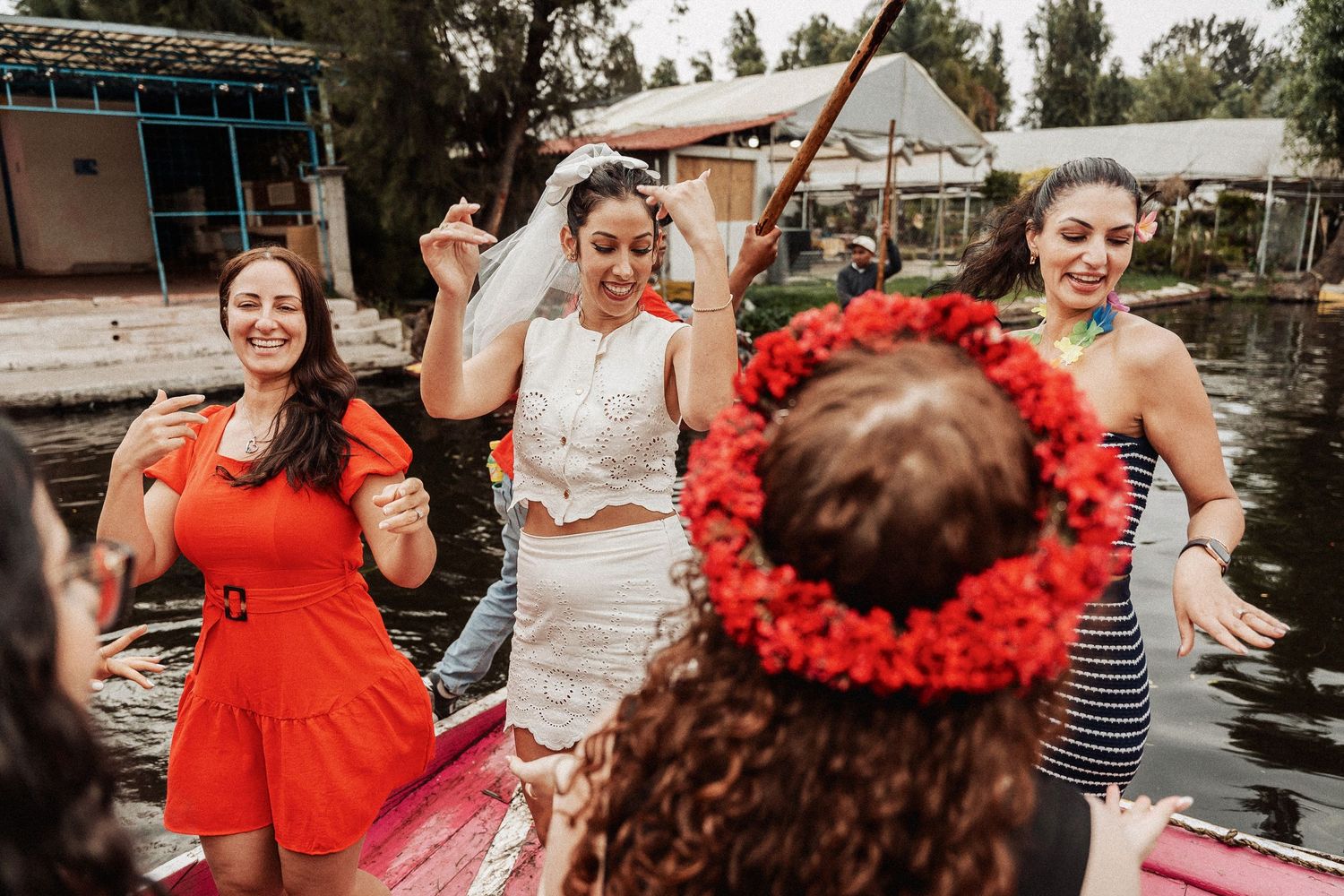 A group of guests dancing and celebrating together at an outdoor party with colorful outfits and decorations.