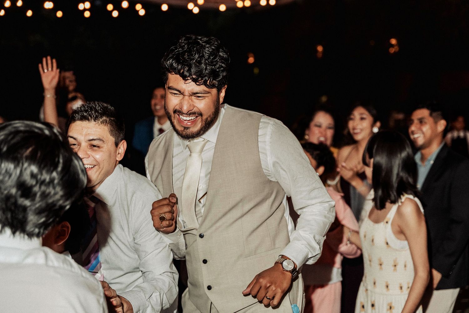 Guests enjoying a lively celebration on the dance floor with festive lighting overhead.
