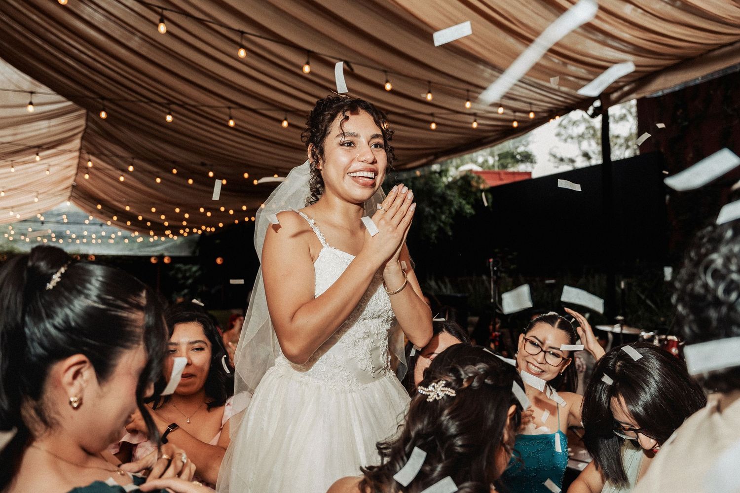 Person in wedding dress celebrating with guests during reception party.