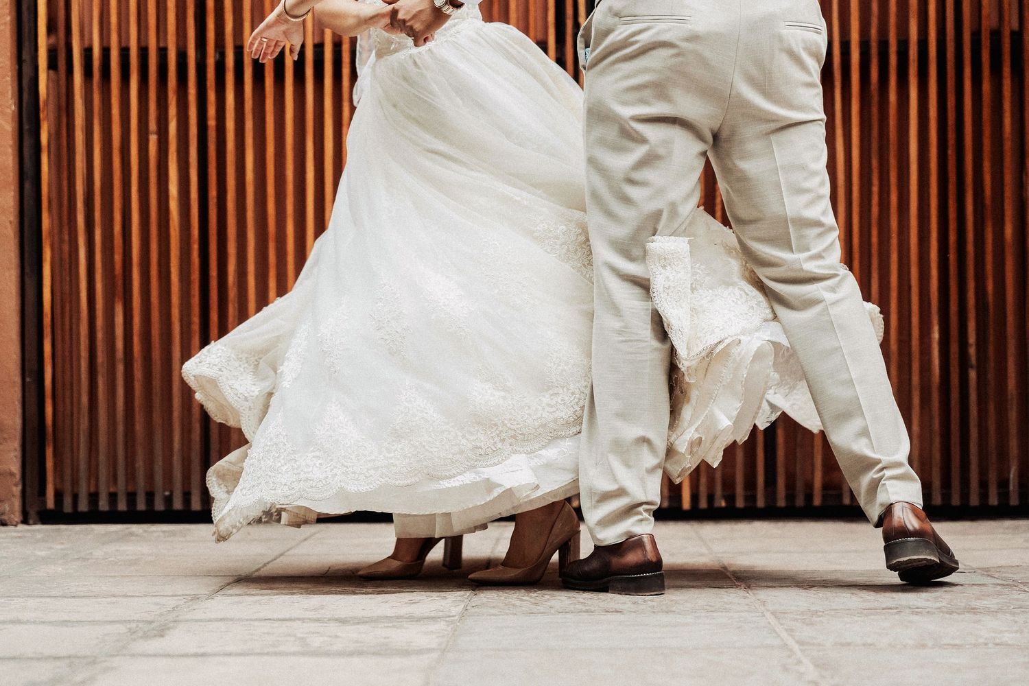 Wedding couple dancing gracefully in an elegant venue with wood paneled walls and white decor.