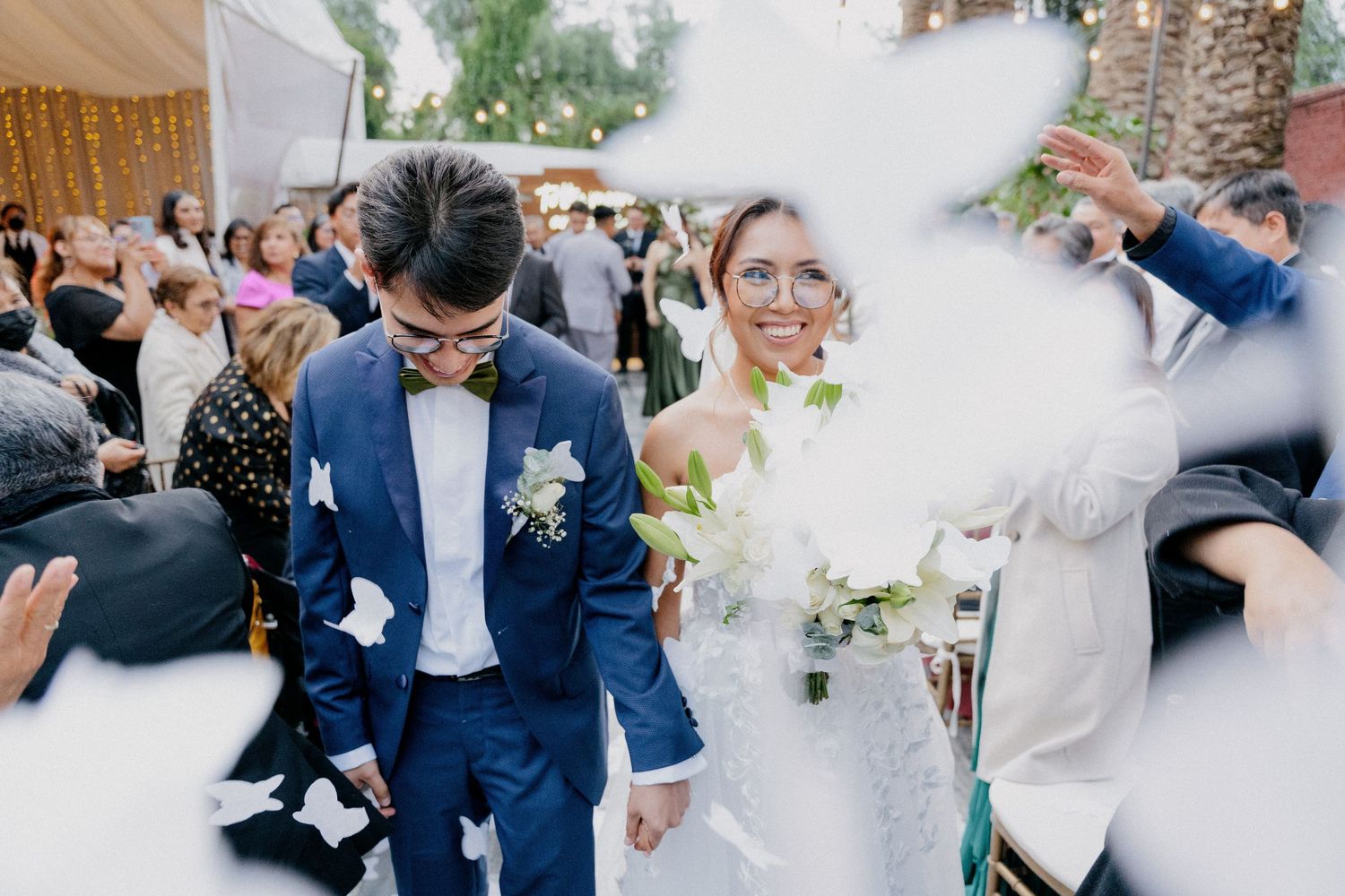 Wedding guests dancing and celebrating together on a dance floor at an indoor reception venue.