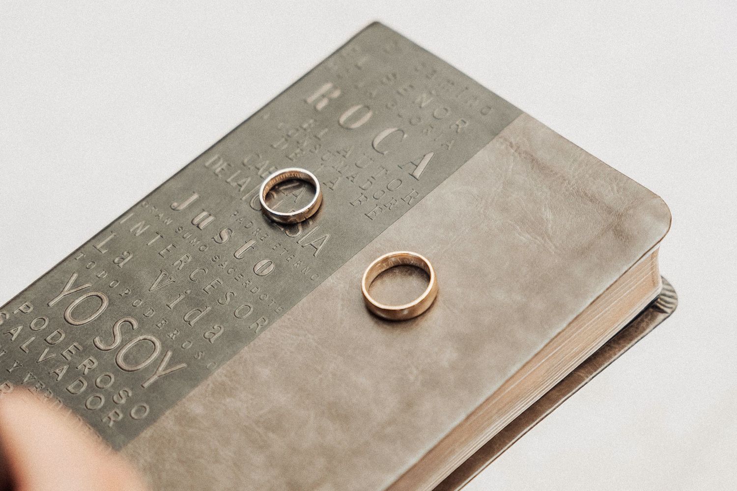 Four silver metal plates showcasing matching wedding rings on a white background, shown progressively closer with each shot.