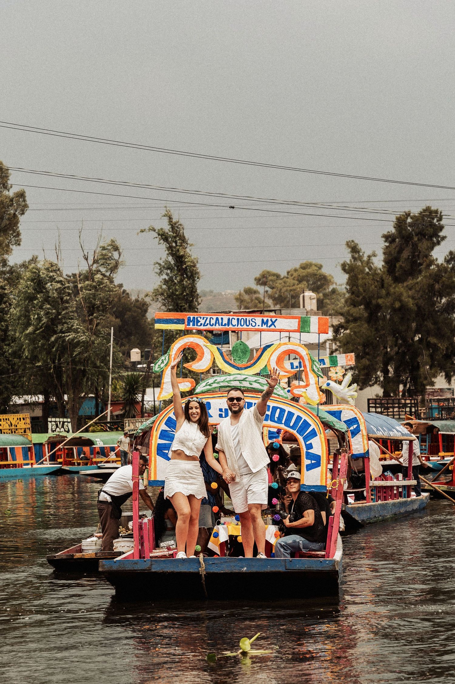A colorful decorated gondola boat carries passengers through a waterway at Xochimilco's famous floating gardens.