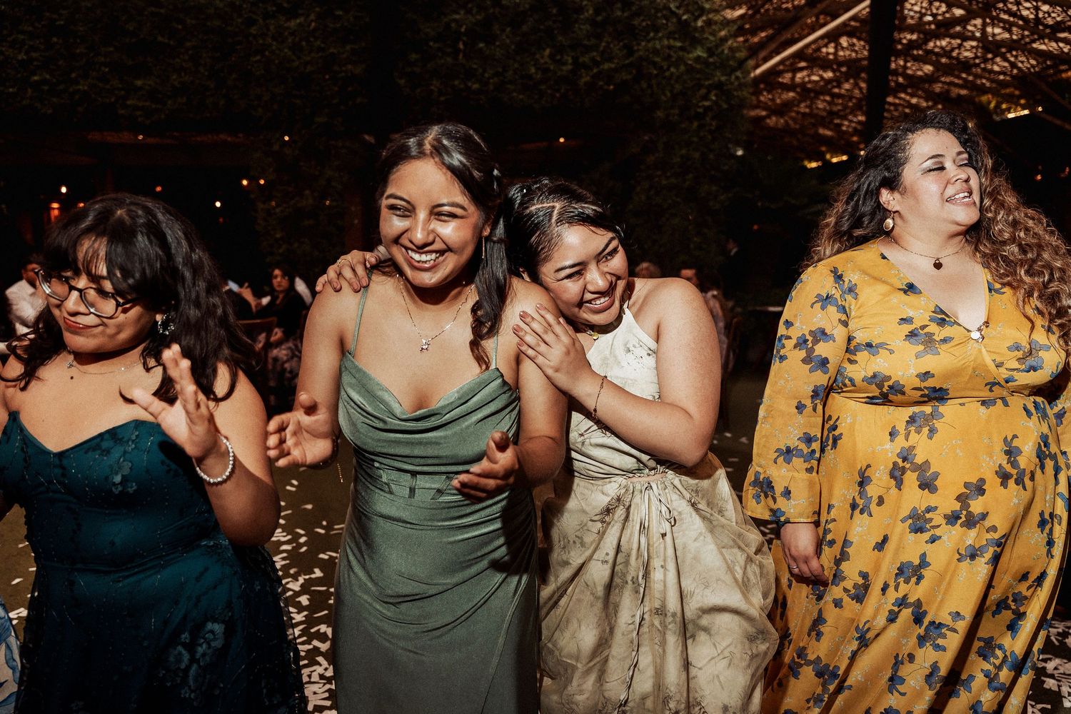 Wedding guests on dancefloor with draped ceiling decorations celebrating during evening reception.