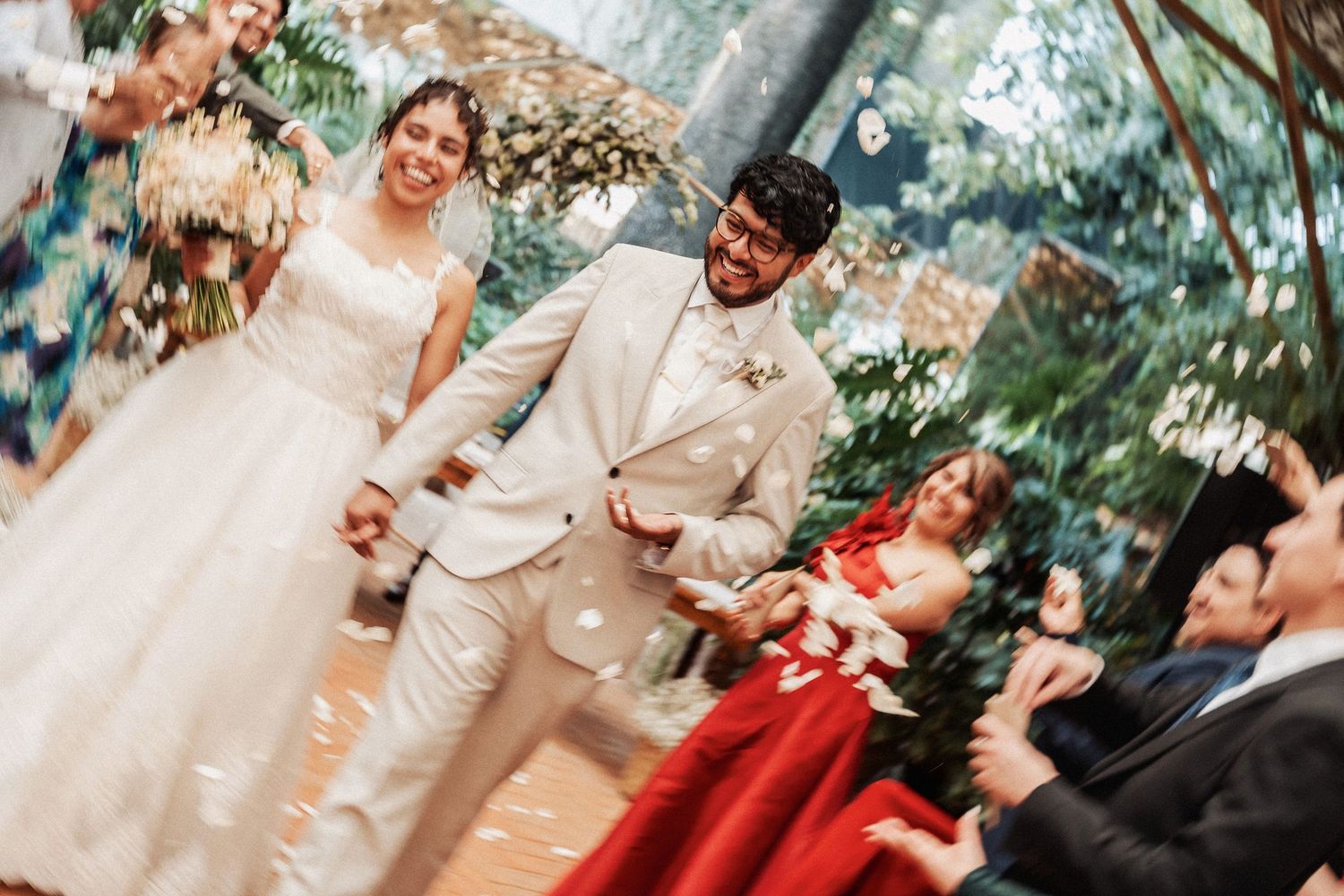 Wedding celebration scene with elegant formal attire and floral decor in natural outdoor setting.