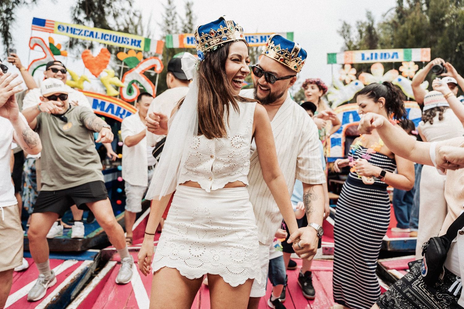 A festive crowd celebrates and dances during an outdoor summer event.
