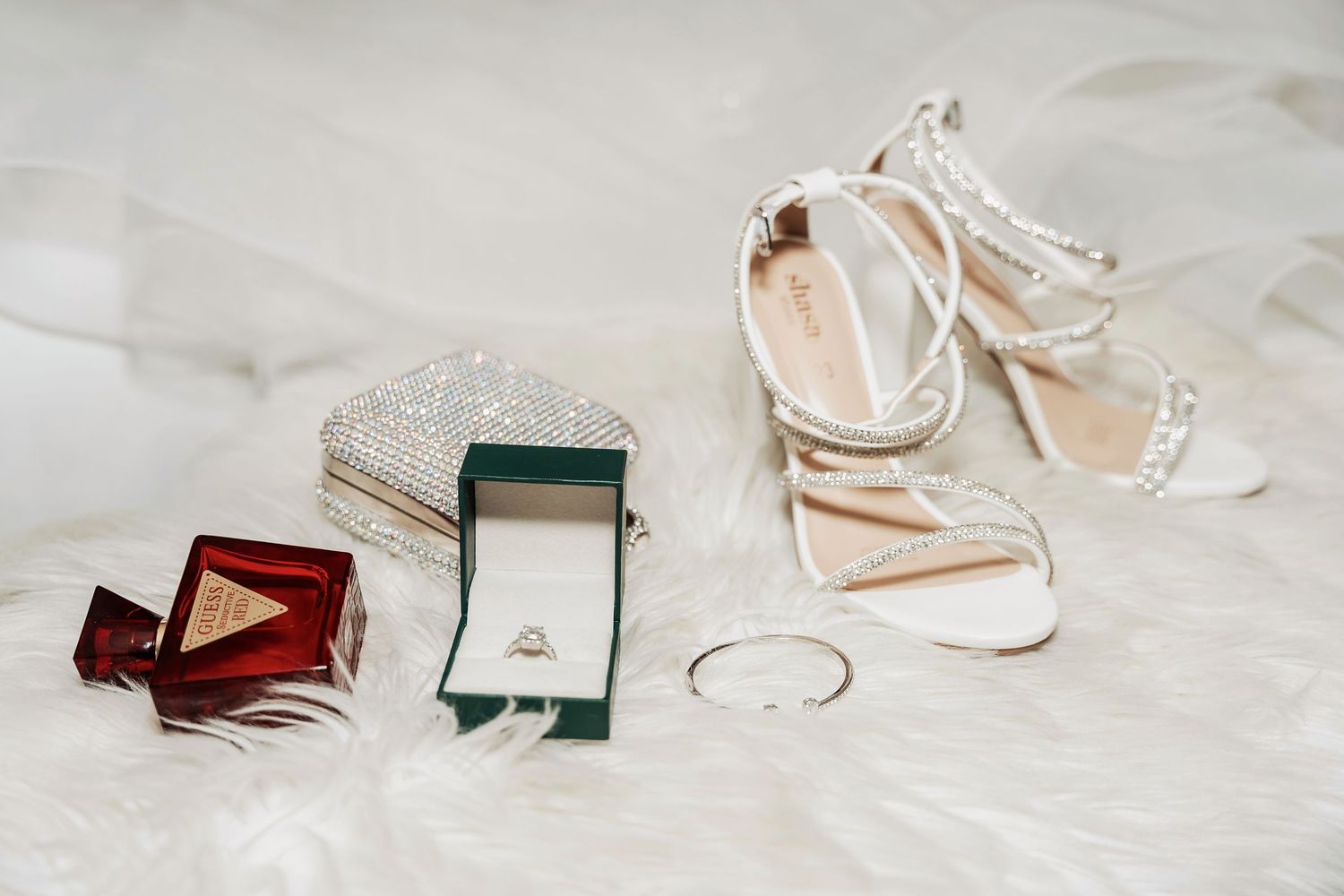 Six elegant glass ring boxes arranged on a white marble surface showcase delicate jewelry pieces.