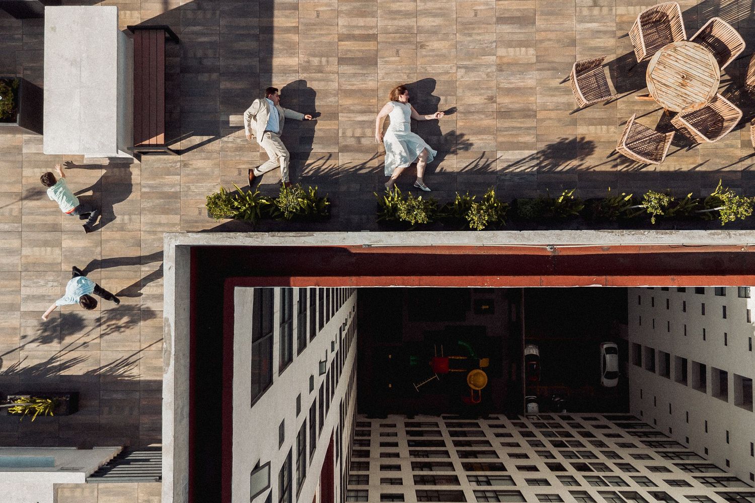 A skateboarder performs a trick on stone steps near a brick wall in an urban setting.