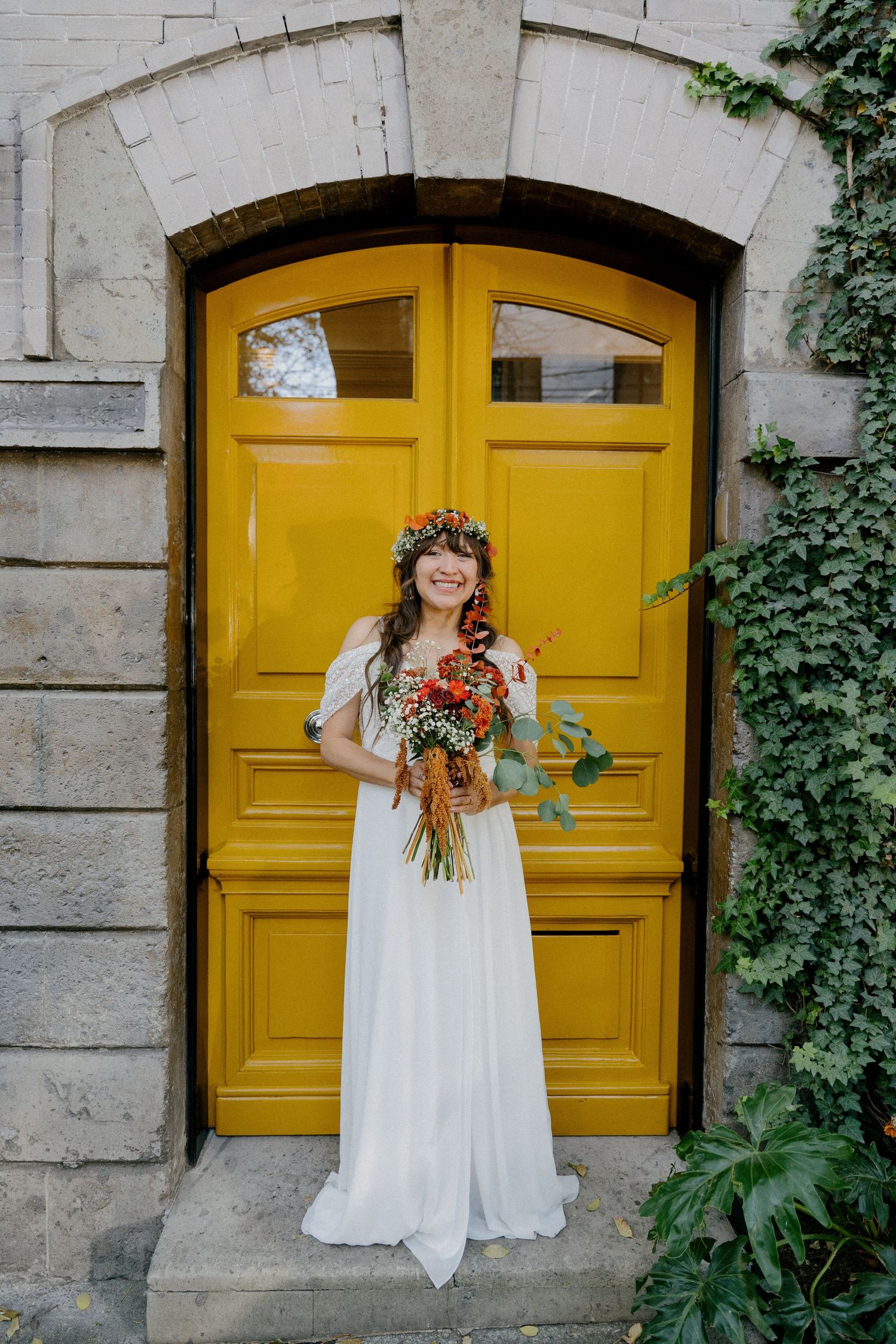 A series of four photos showing a white wedding dress against bright yellow doors with stone walls and green ivy.