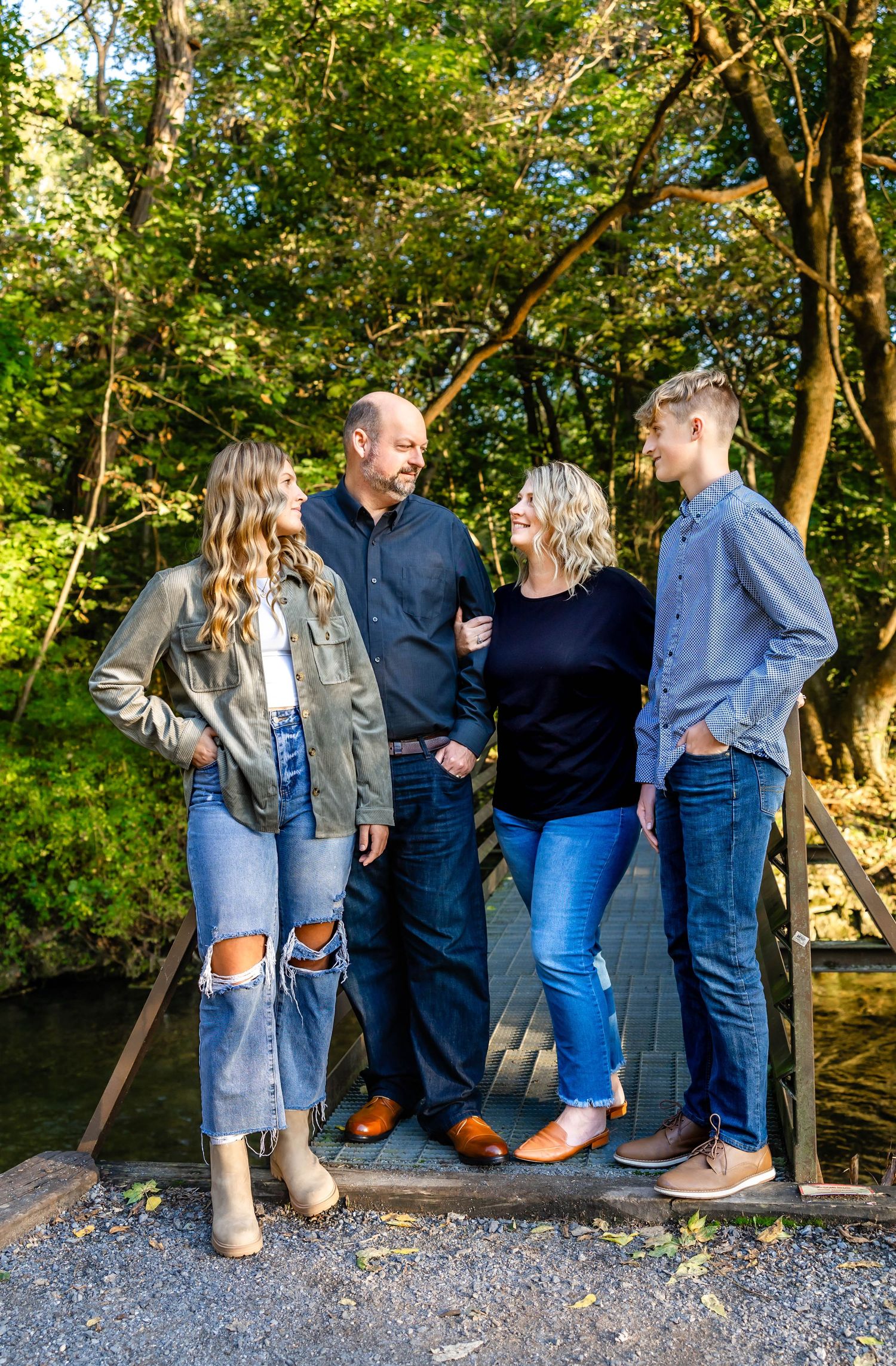 Candid group shot on wooden walkway with sunlit forest background.