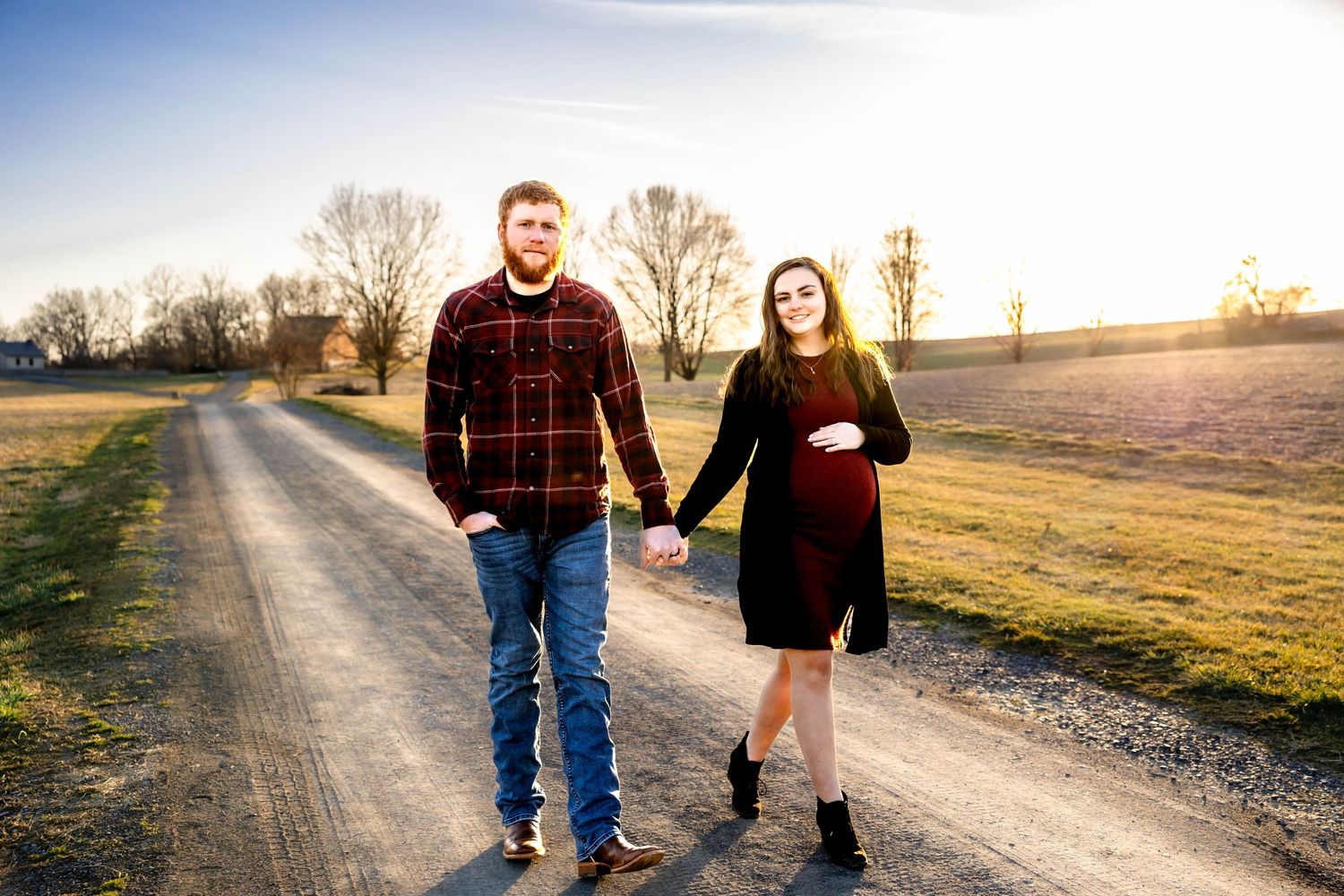 Couple walking together on country path during sunset.