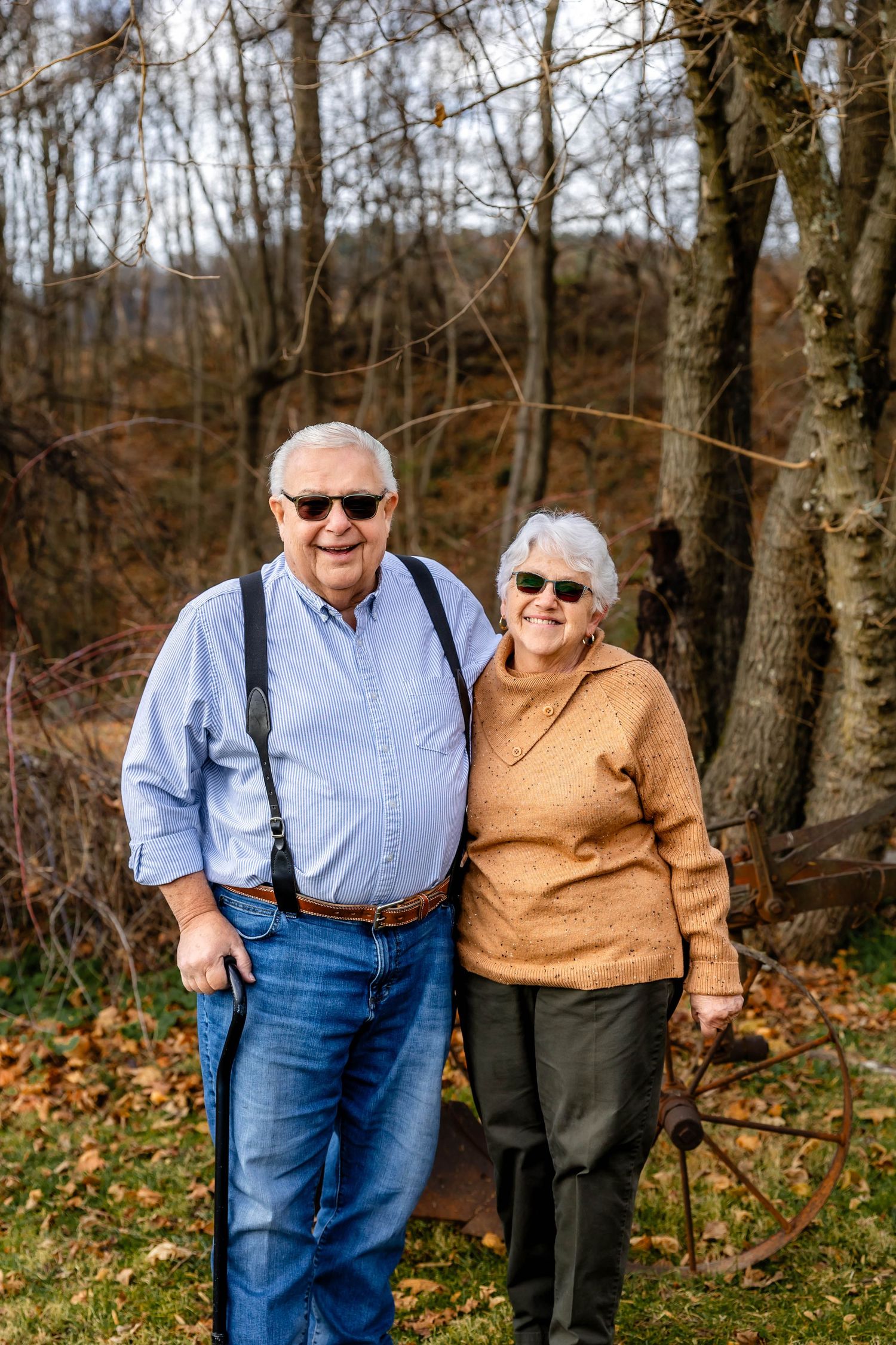 Senior couple smiling together during autumn walk in wooded area.