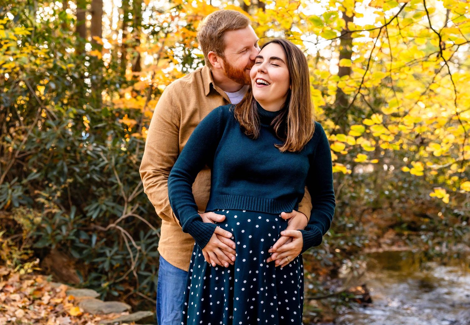Couple shares loving embrace surrounded by golden autumn trees.