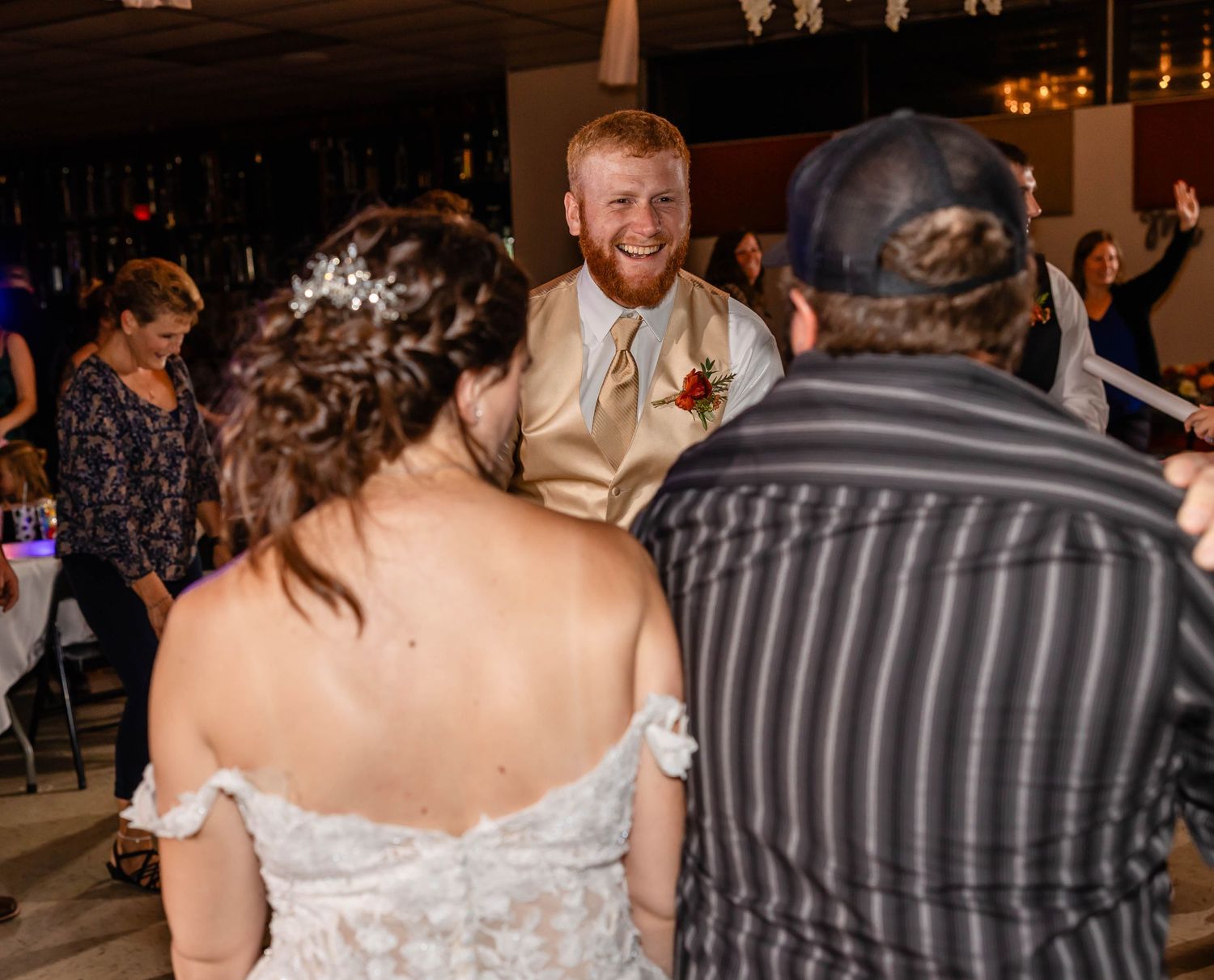 Wedding reception party scene with guests celebrating and dancing.