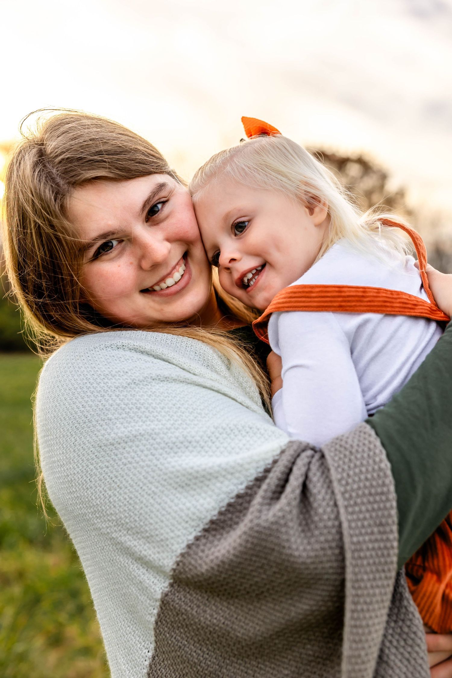 Joyful embrace between parent and child outdoors in autumn setting.