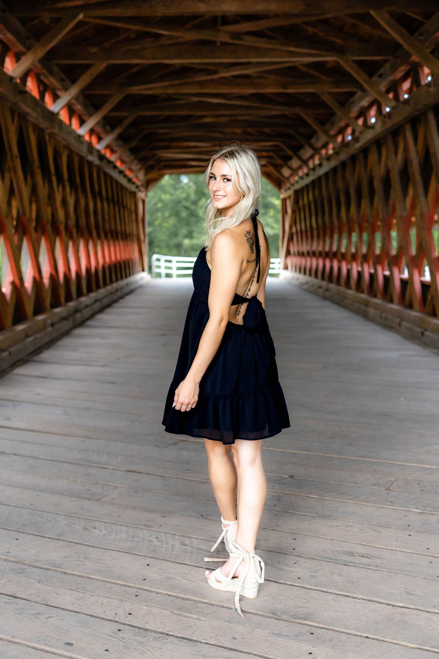 Side profile portrait in a black dress inside a historic covered bridge.