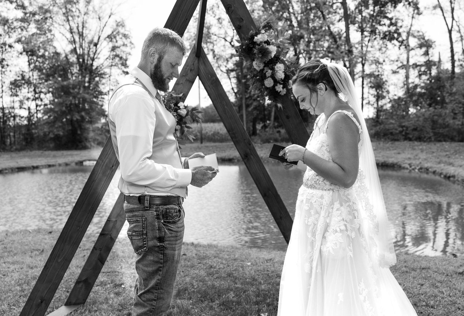 Black and white capture of wedding ceremony vows exchange outdoors.