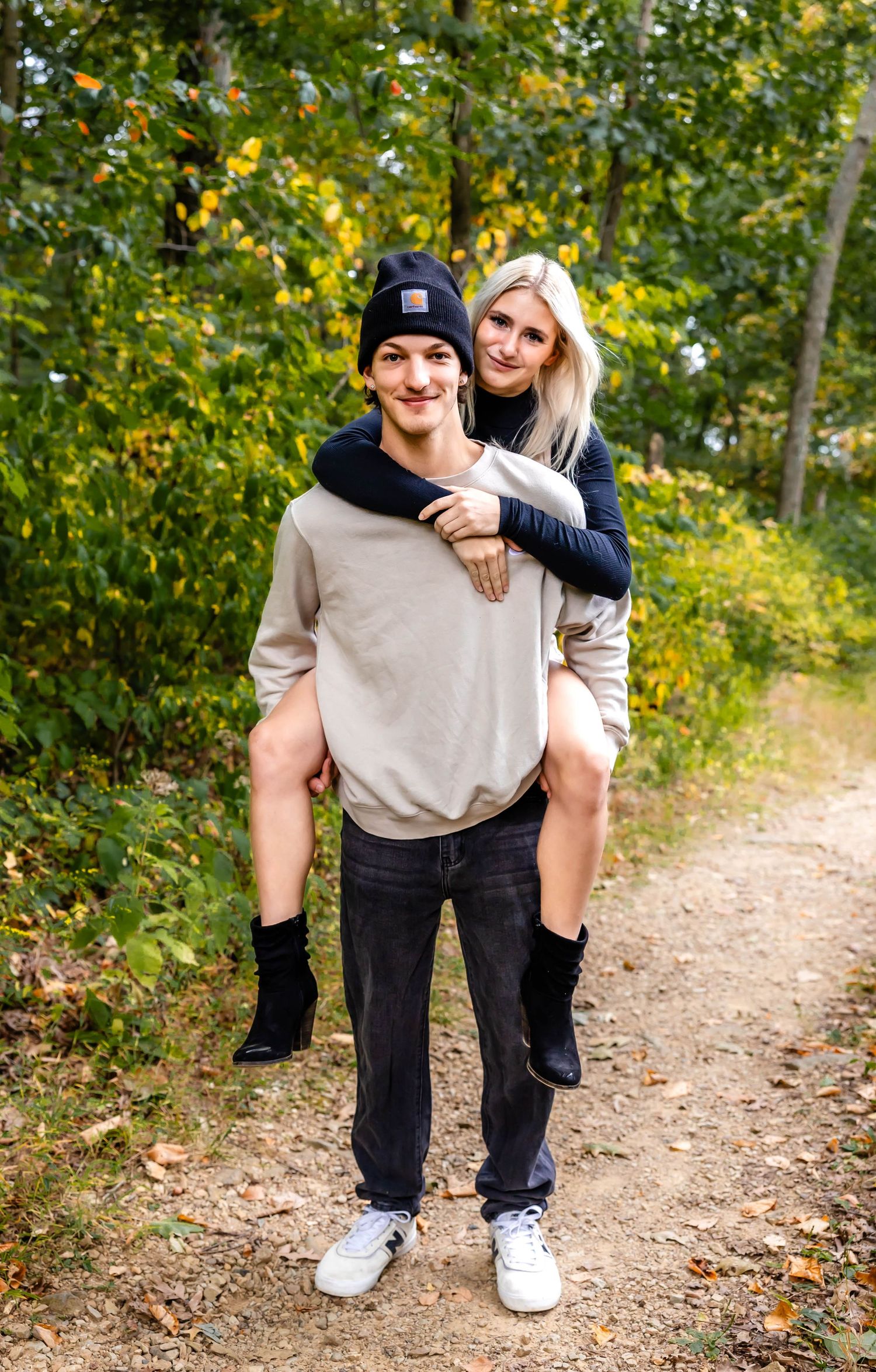 A playful piggyback ride moment captured on a scenic fall hiking trail.