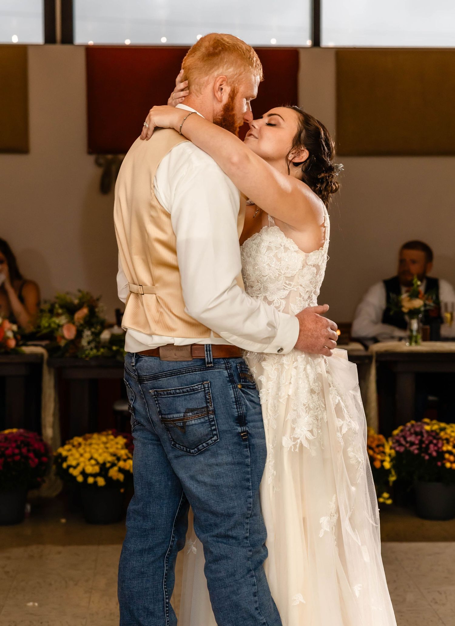 A romantic dance moment captured at a reception venue with guests seated in the background.