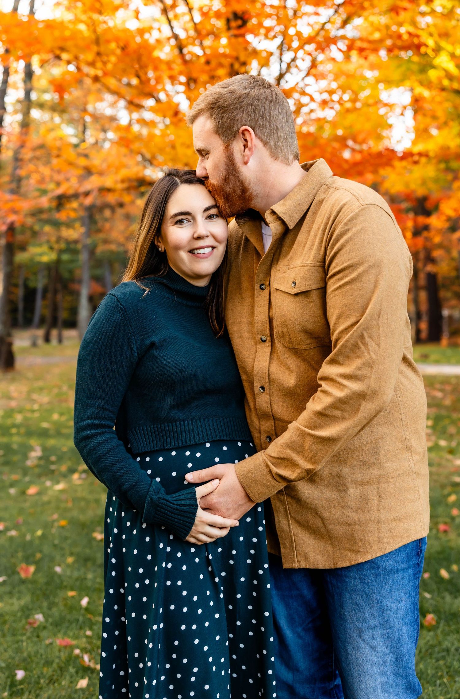 Couple sharing tender moment together surrounded by autumn foliage.