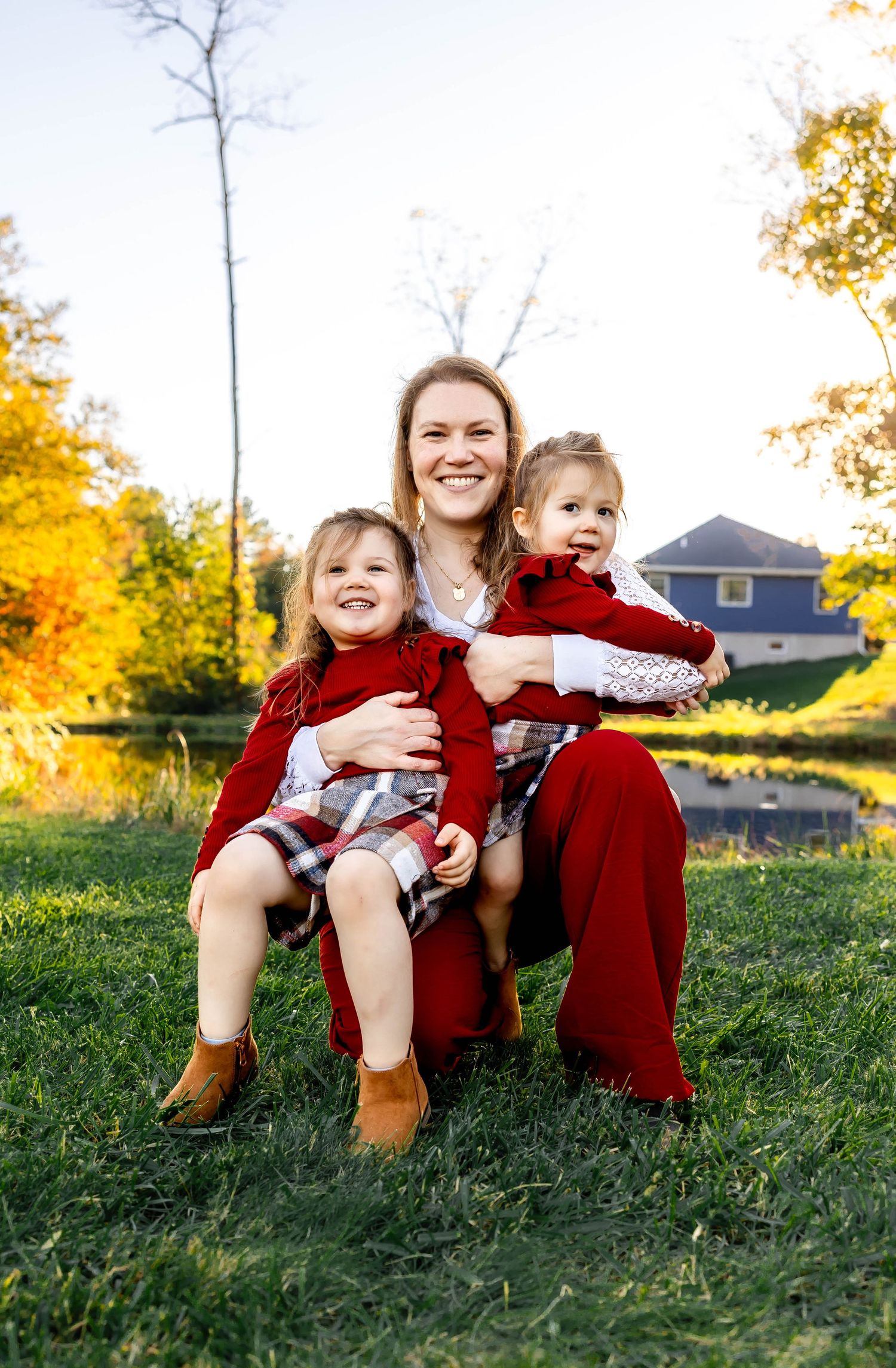 Joyful outdoor portrait in autumn setting with matching red outfits.