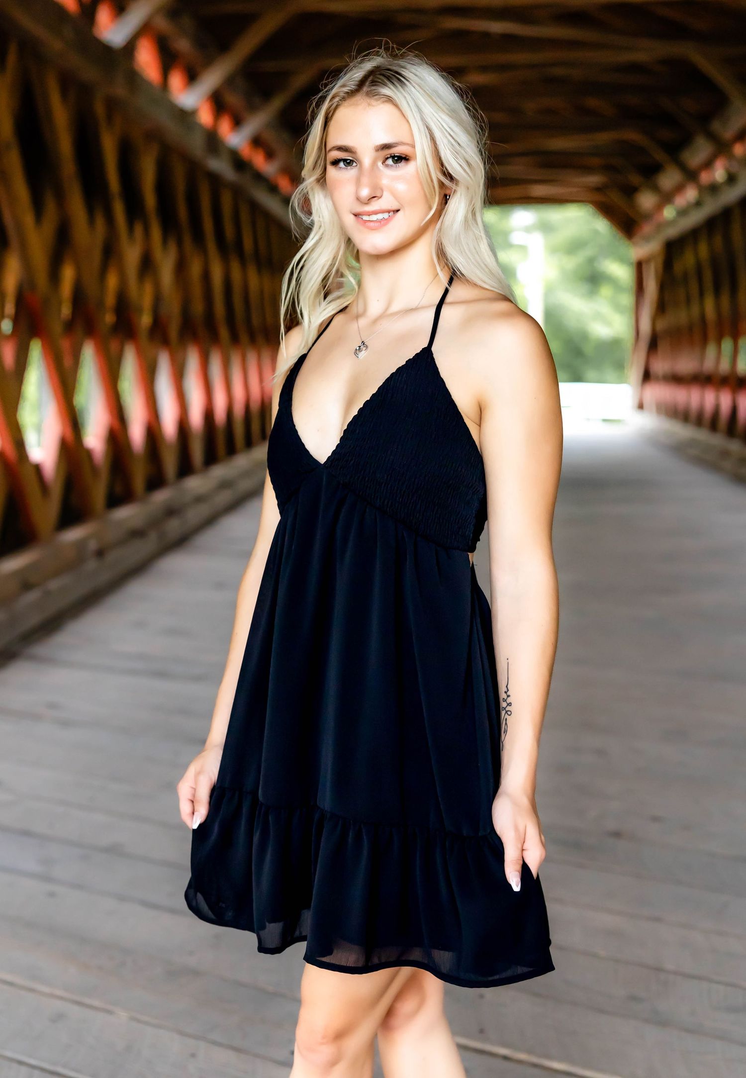 Fashion portrait taken inside a rustic covered bridge featuring a black dress.