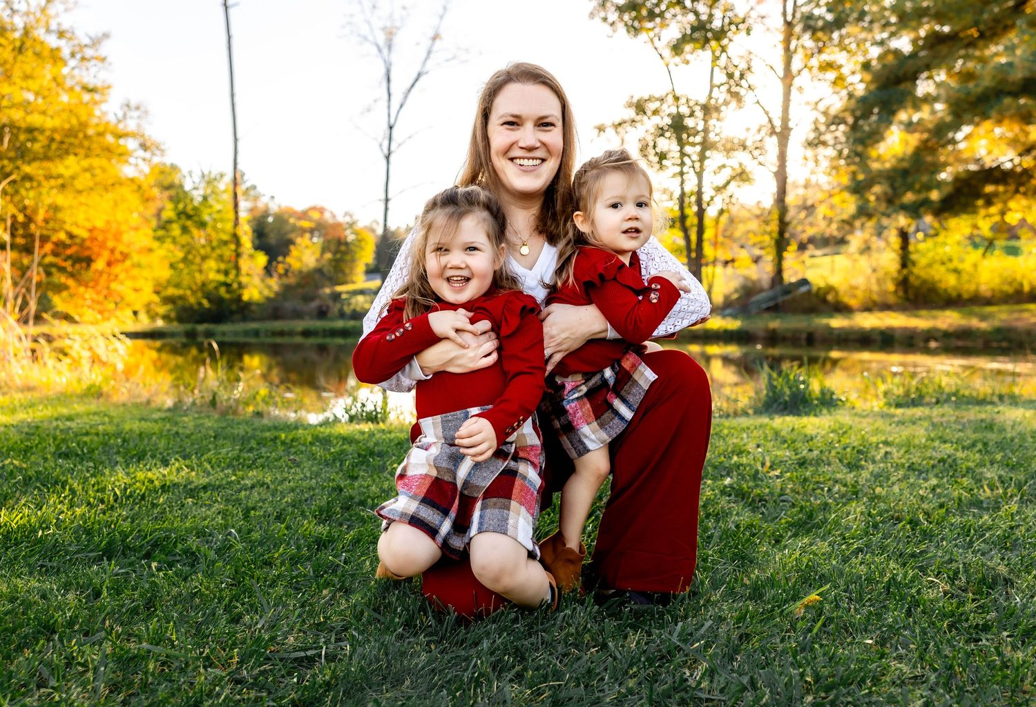 A joyful autumn family portrait in a park with golden sunlight and trees.