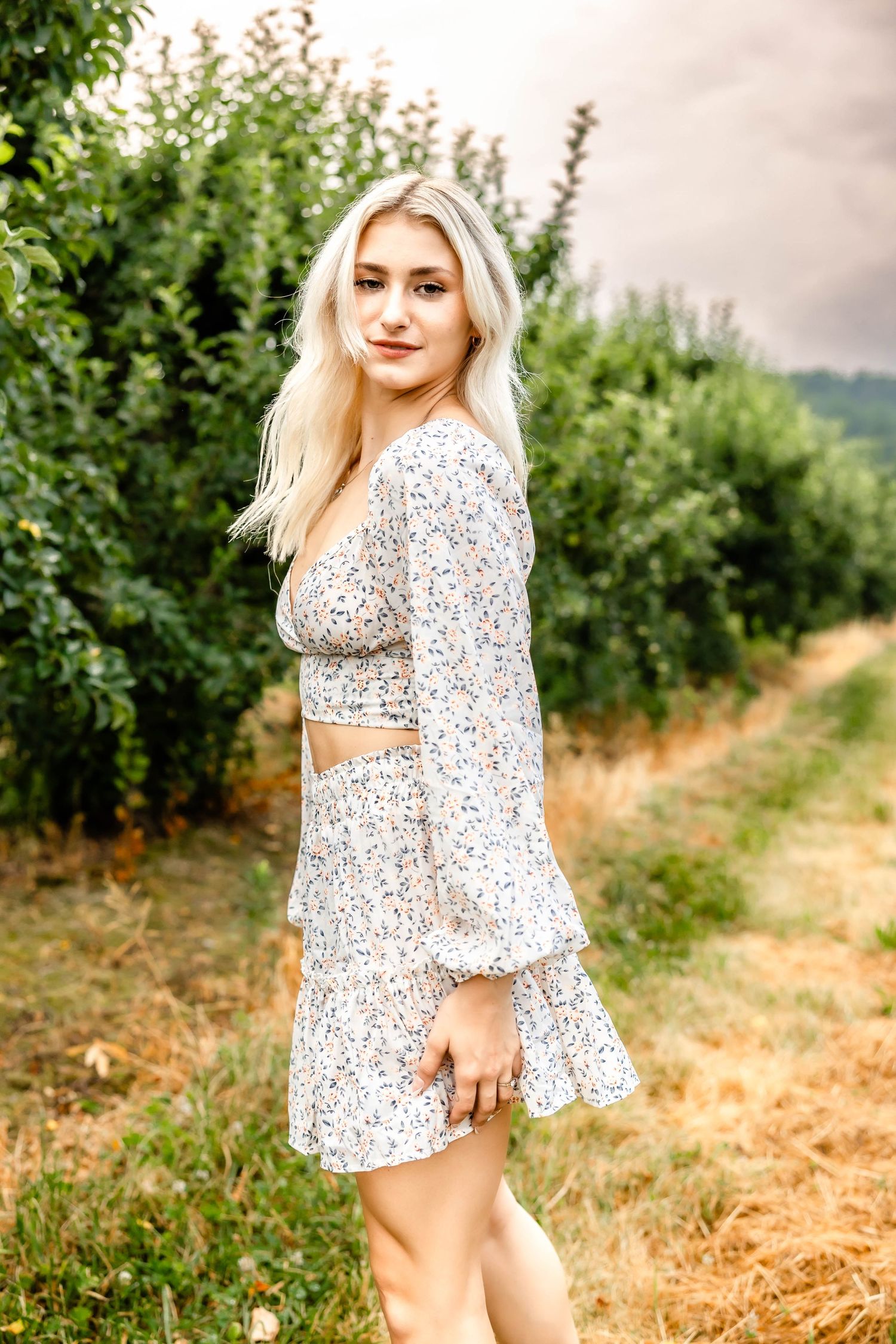 Stylish two-piece floral dress with balloon sleeves captured in an orchard setting.