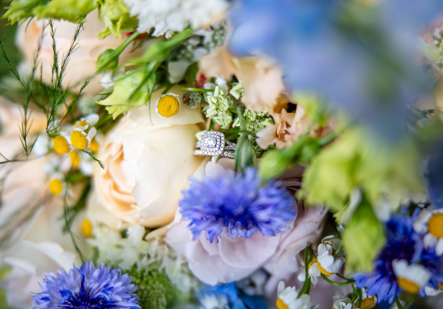 Close-up of a delicate floral arrangement with yellow and blue blooms in soft focus with dreamy bokeh effect.