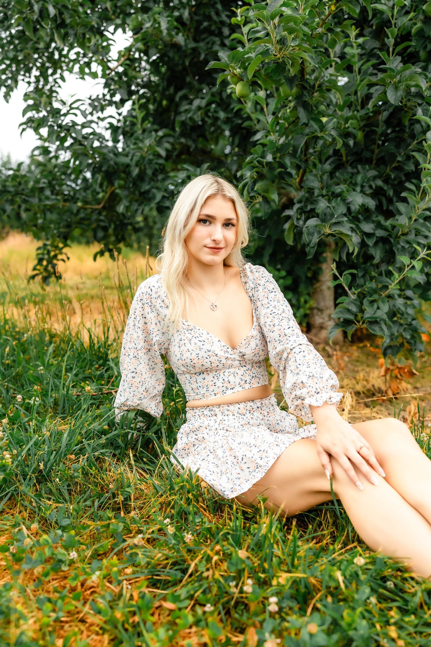 Summer fashion portrait of a floral coordinating set photographed in a lush orchard setting.