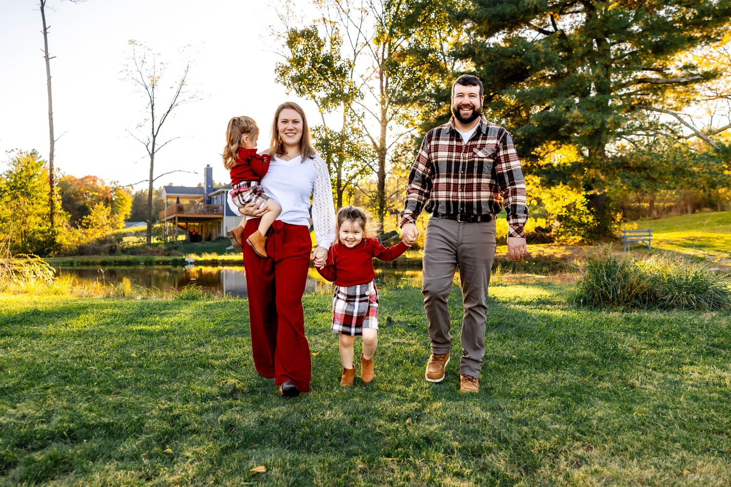 A family walks together through a sunny autumn field during golden hour.