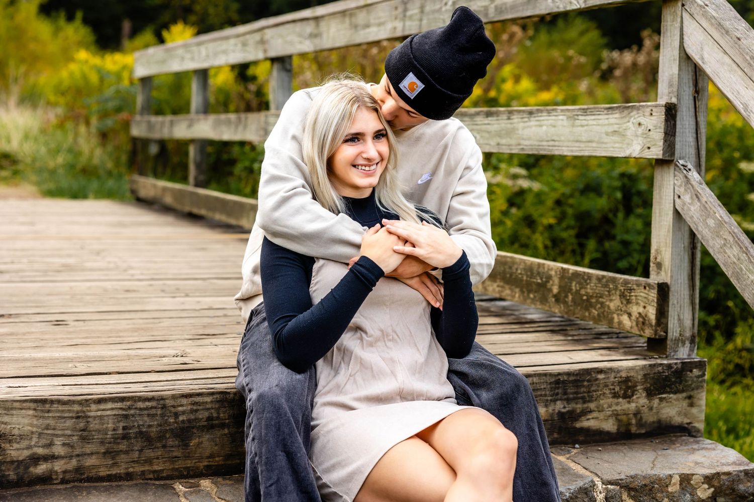 Sweet candid moment between couple on rustic wooden steps outdoors.