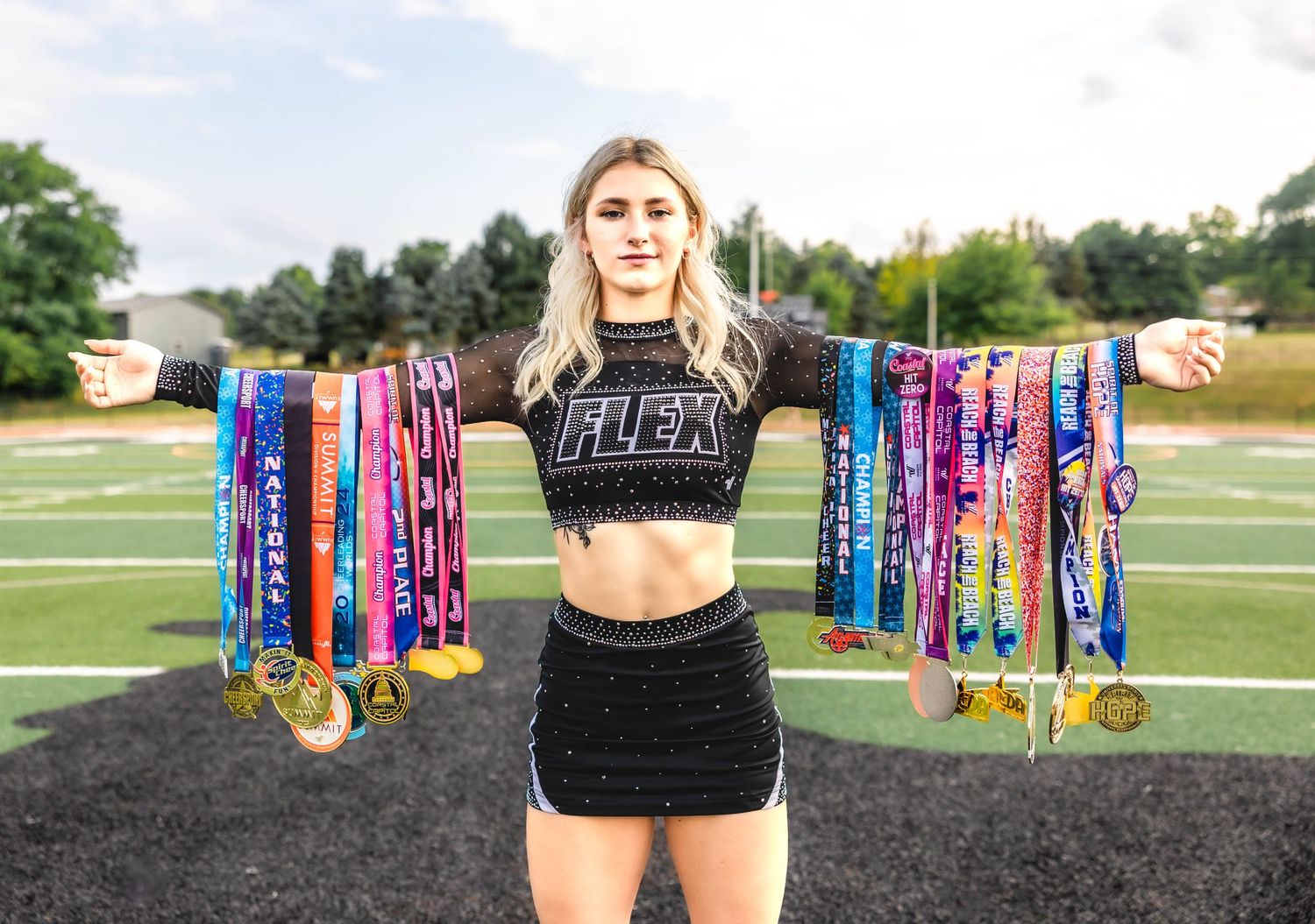Athletic achievement display with colorful medals and awards on sports field.