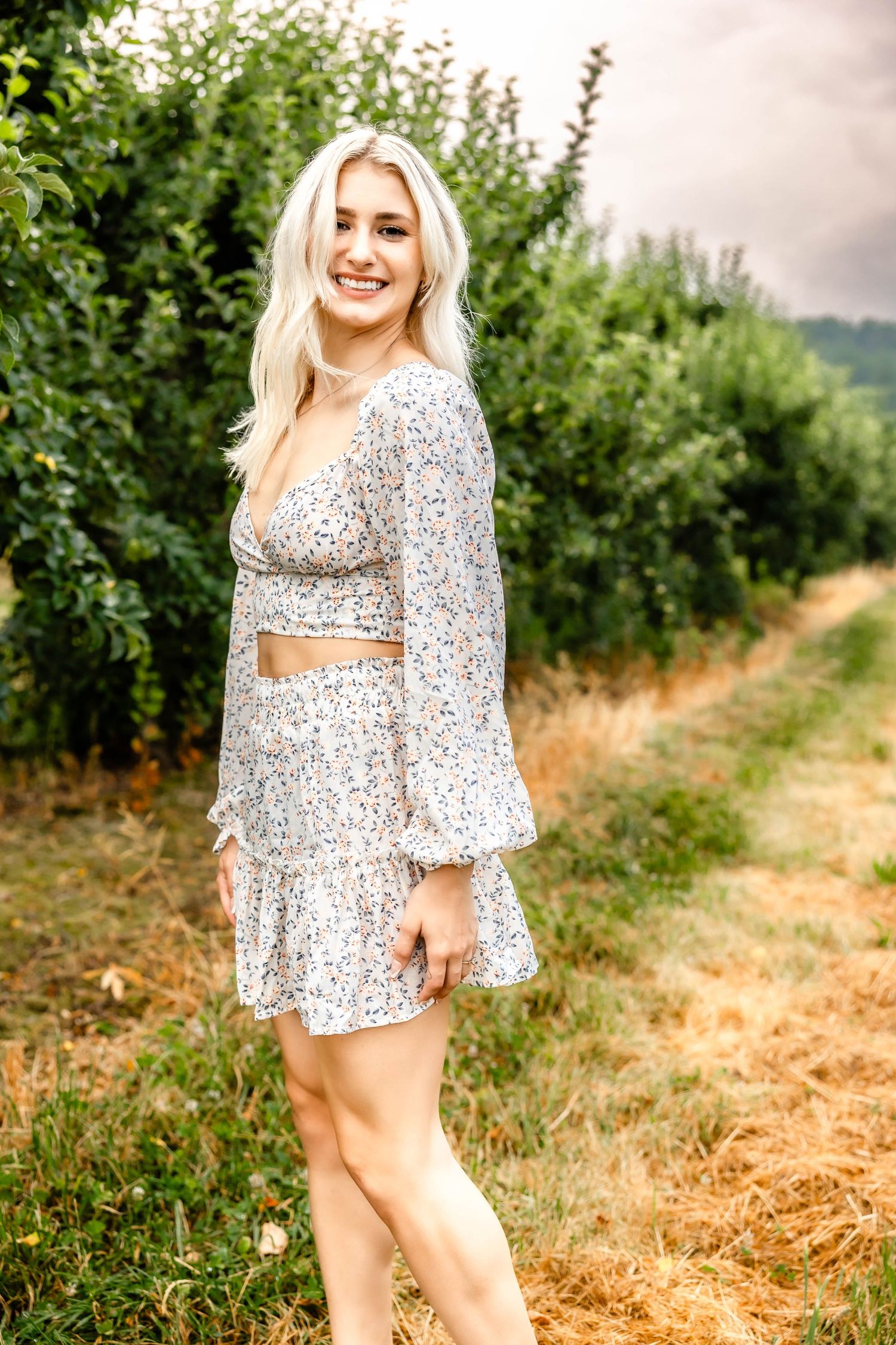 Two-piece floral outfit with bell sleeves photographed in a scenic country setting.