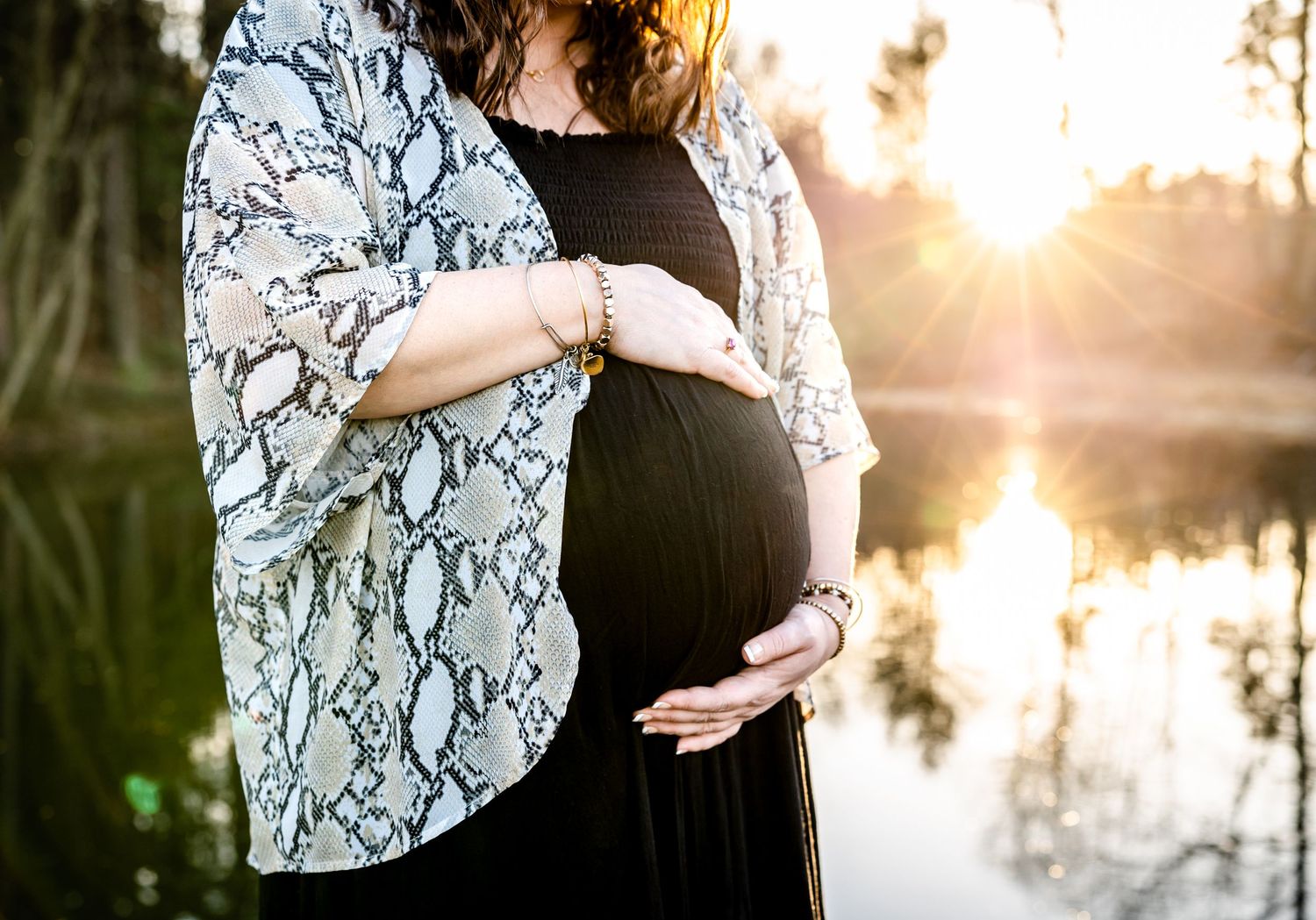 Maternity photo by lake at sunset wearing snake print kimono.