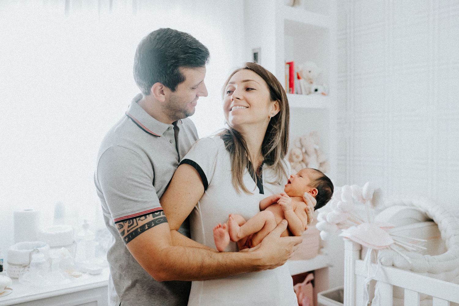 Family photos showing tender moments with newborn baby in bright nursery setting.