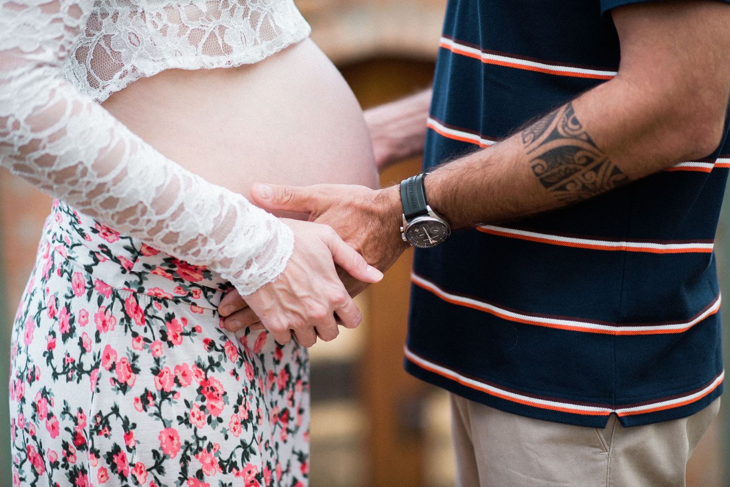 Close-up details of couple wearing navy striped shirt and white lace dress.