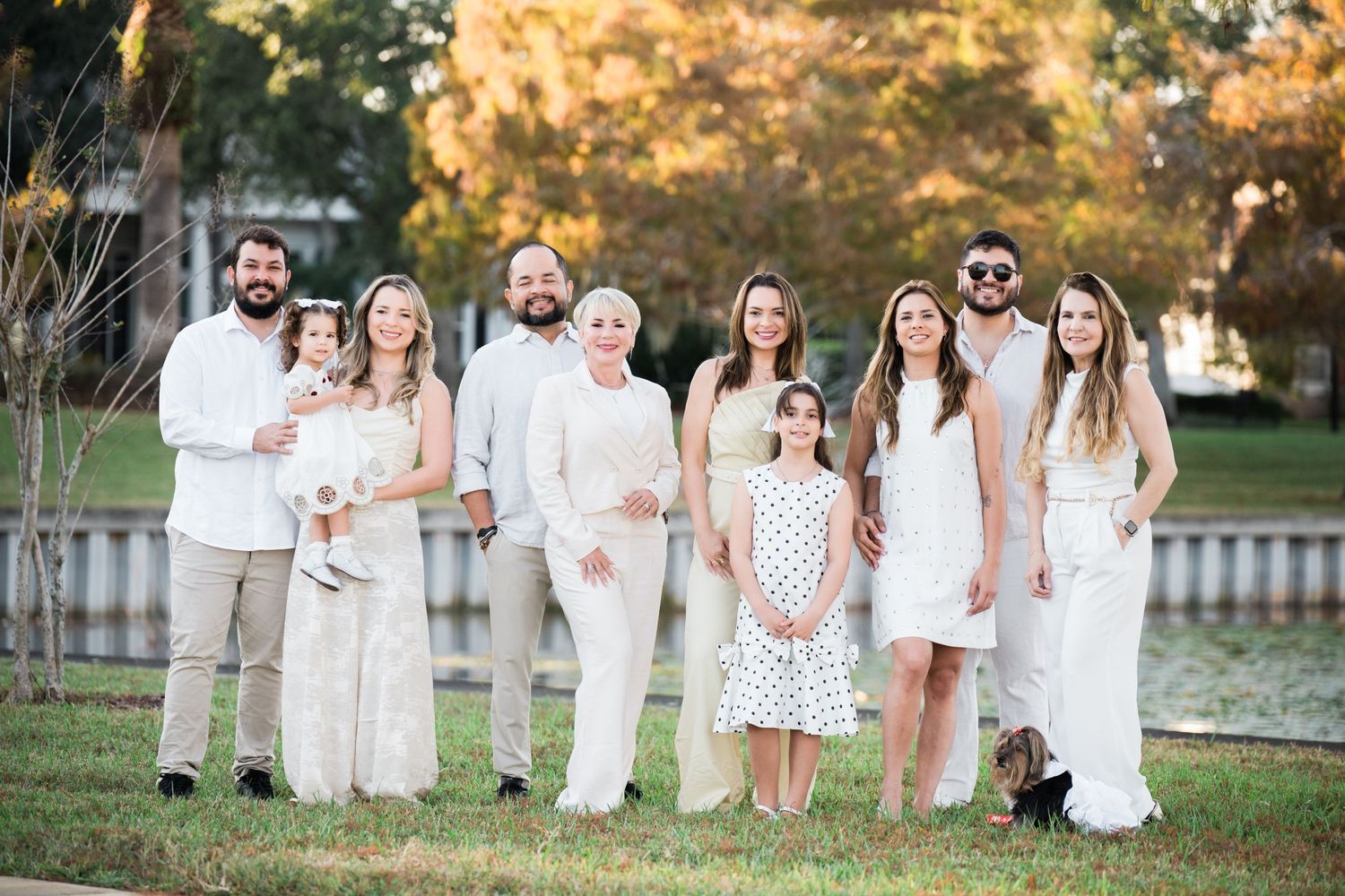 Candid group photo of people in white outfits laughing together outdoors.