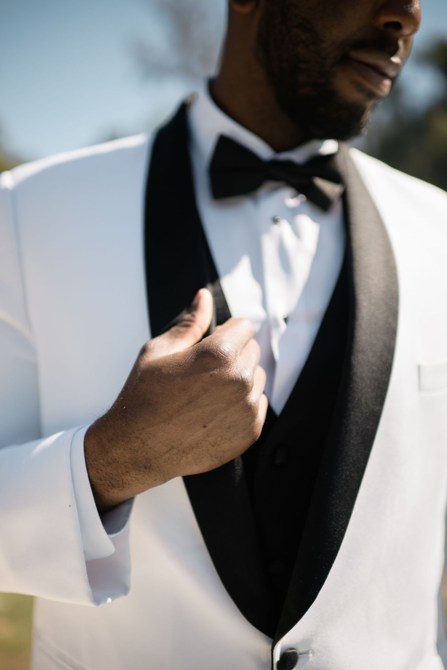 Close-up of white tuxedo jacket with black bow tie and vest.