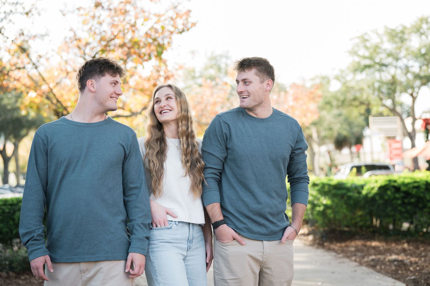 A group poses casually on a path during an autumn outdoor photo session.
