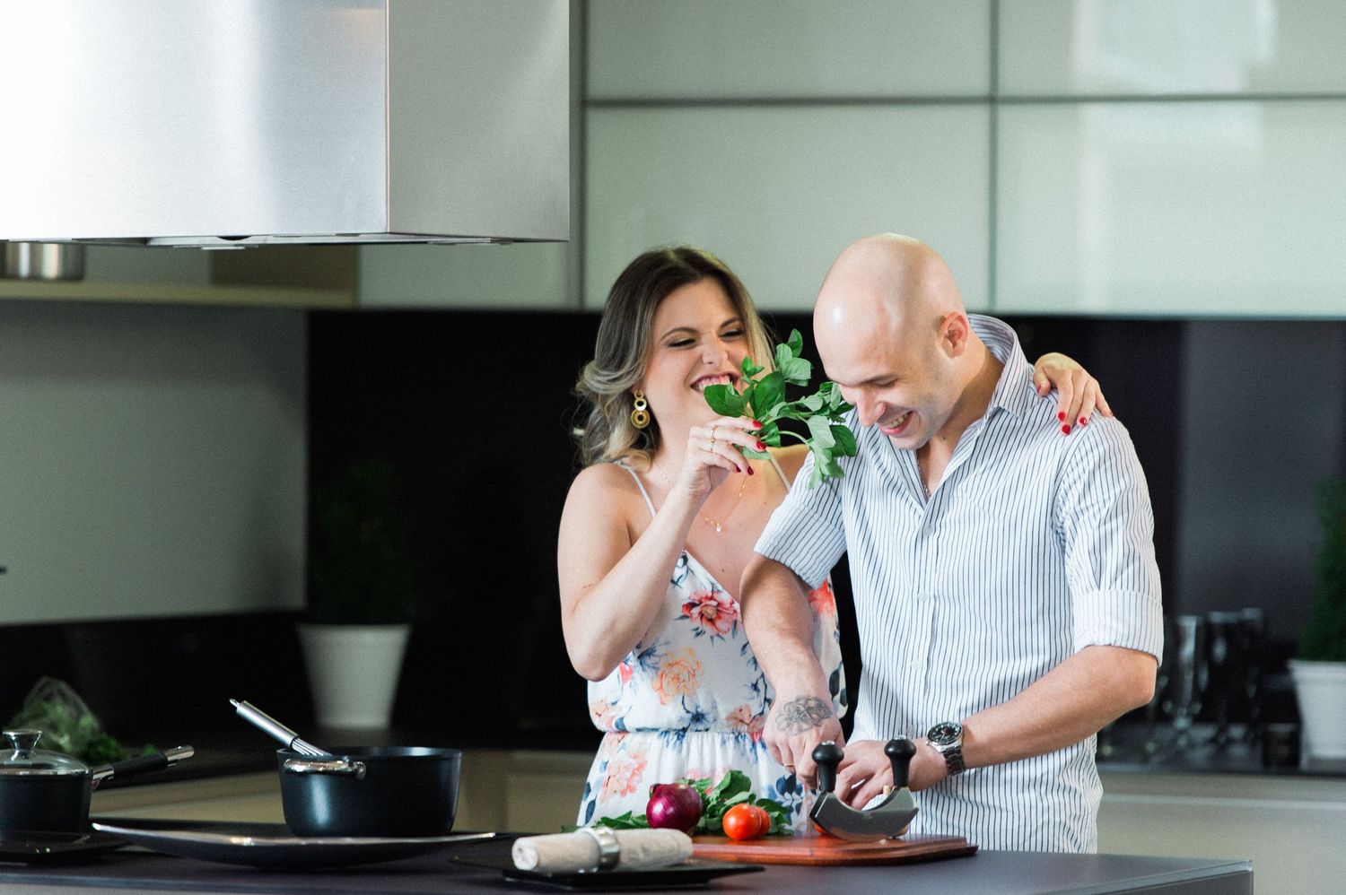 Couple enjoying drinks and conversation in modern kitchen setting.
