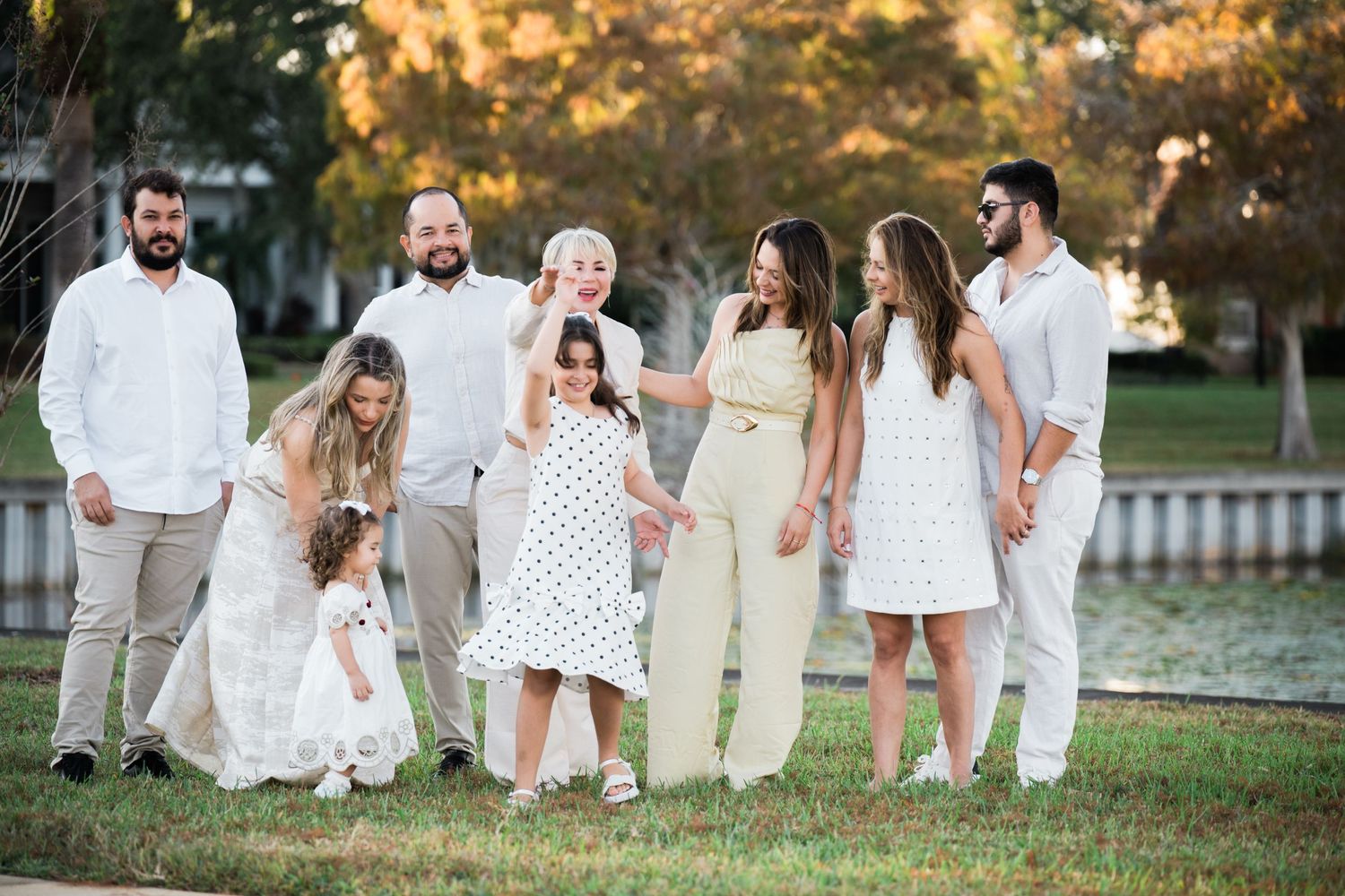 Group in white attire shares joyful moment during outdoor photo session.