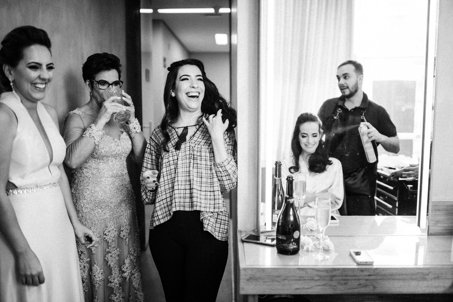 Black and white candid shots of wedding guests laughing and celebrating.