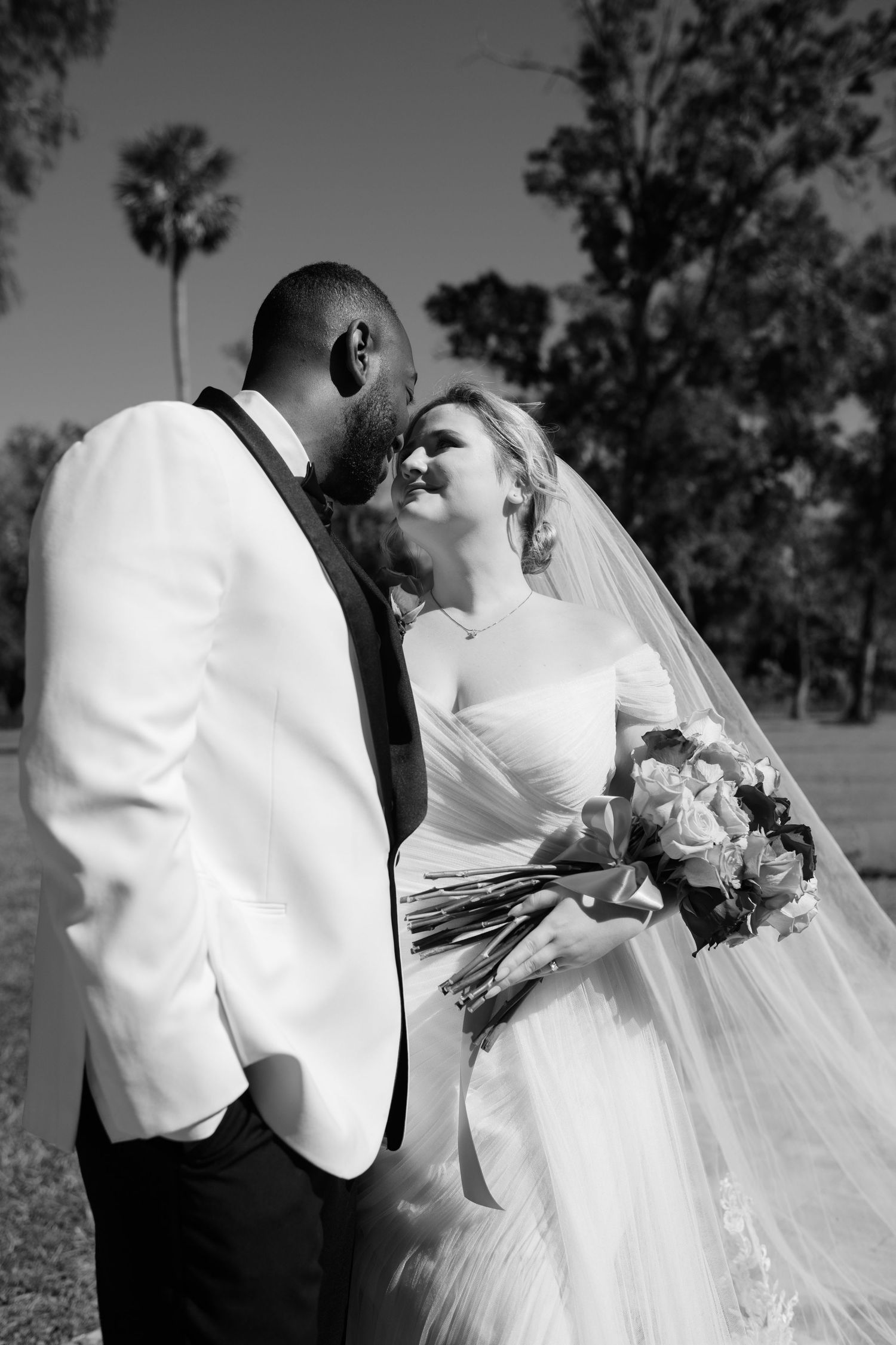 Black and white wedding portrait capturing intimate moments between the newlyweds.